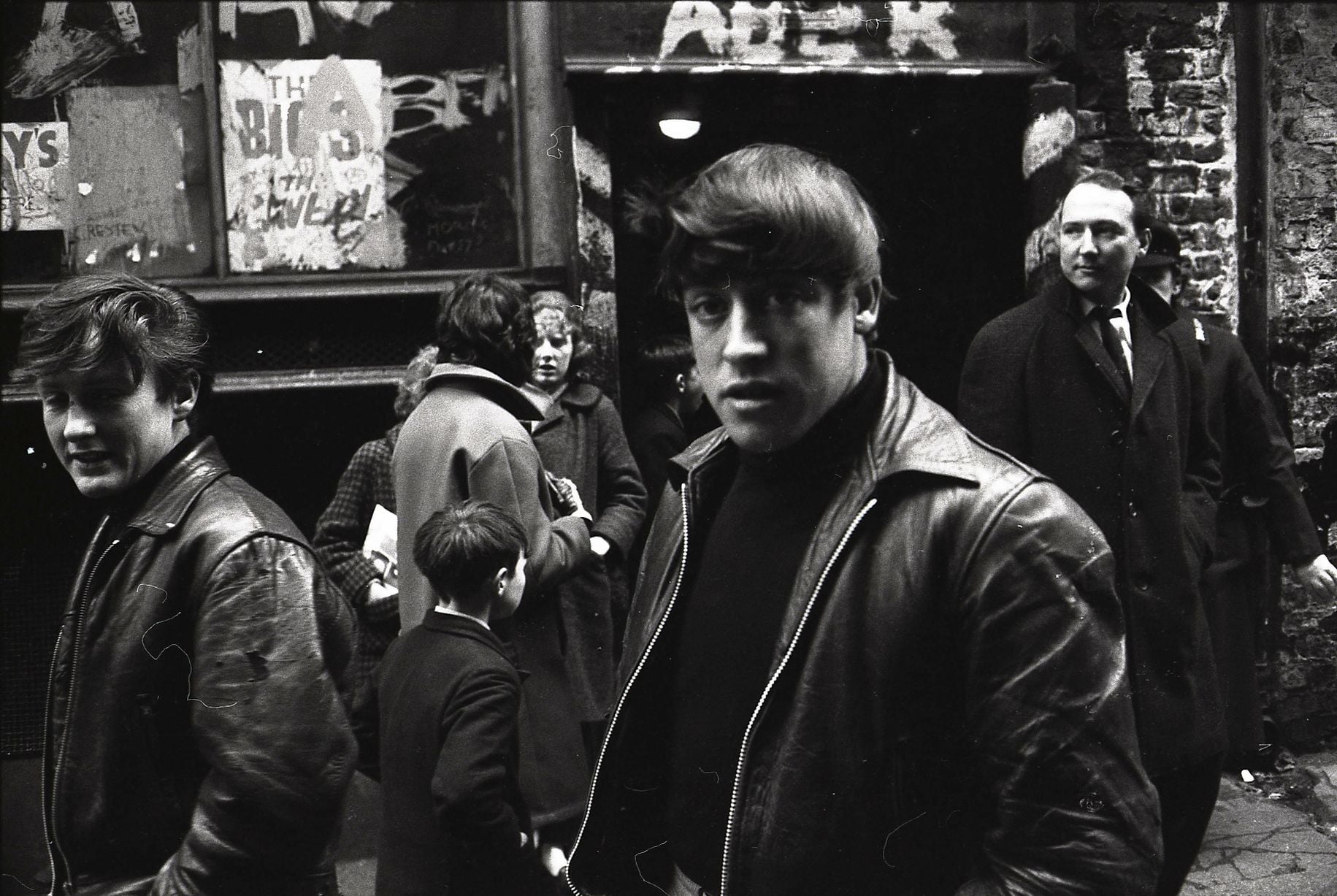 Jeunes hommes devant le Cavern Club, à Liverpool, sur Mathew Street, portant des vestes en cuir. Vers 1964