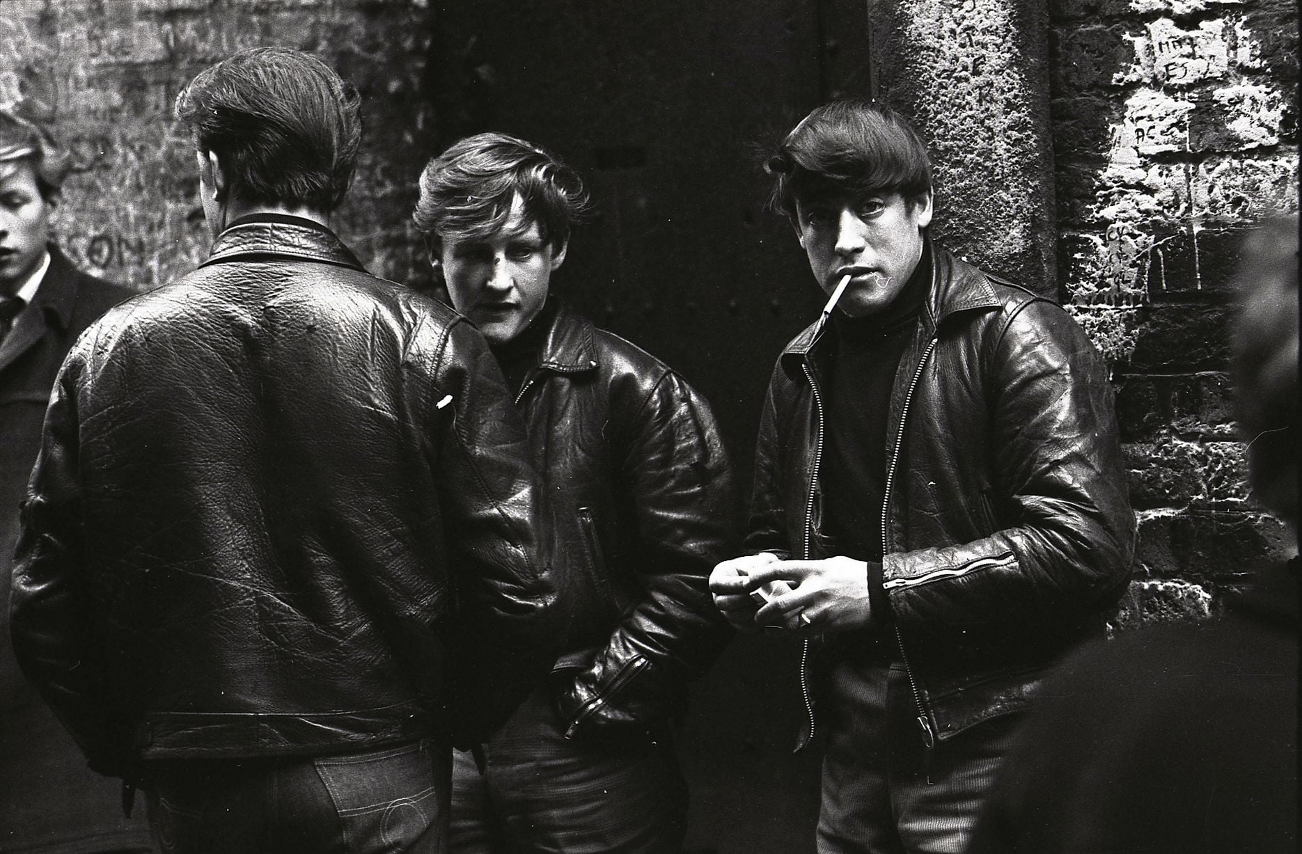 Jeunes hommes devant le Cavern Club, à Liverpool, sur Mathew Street, portant des vestes en cuir. Vers 1964