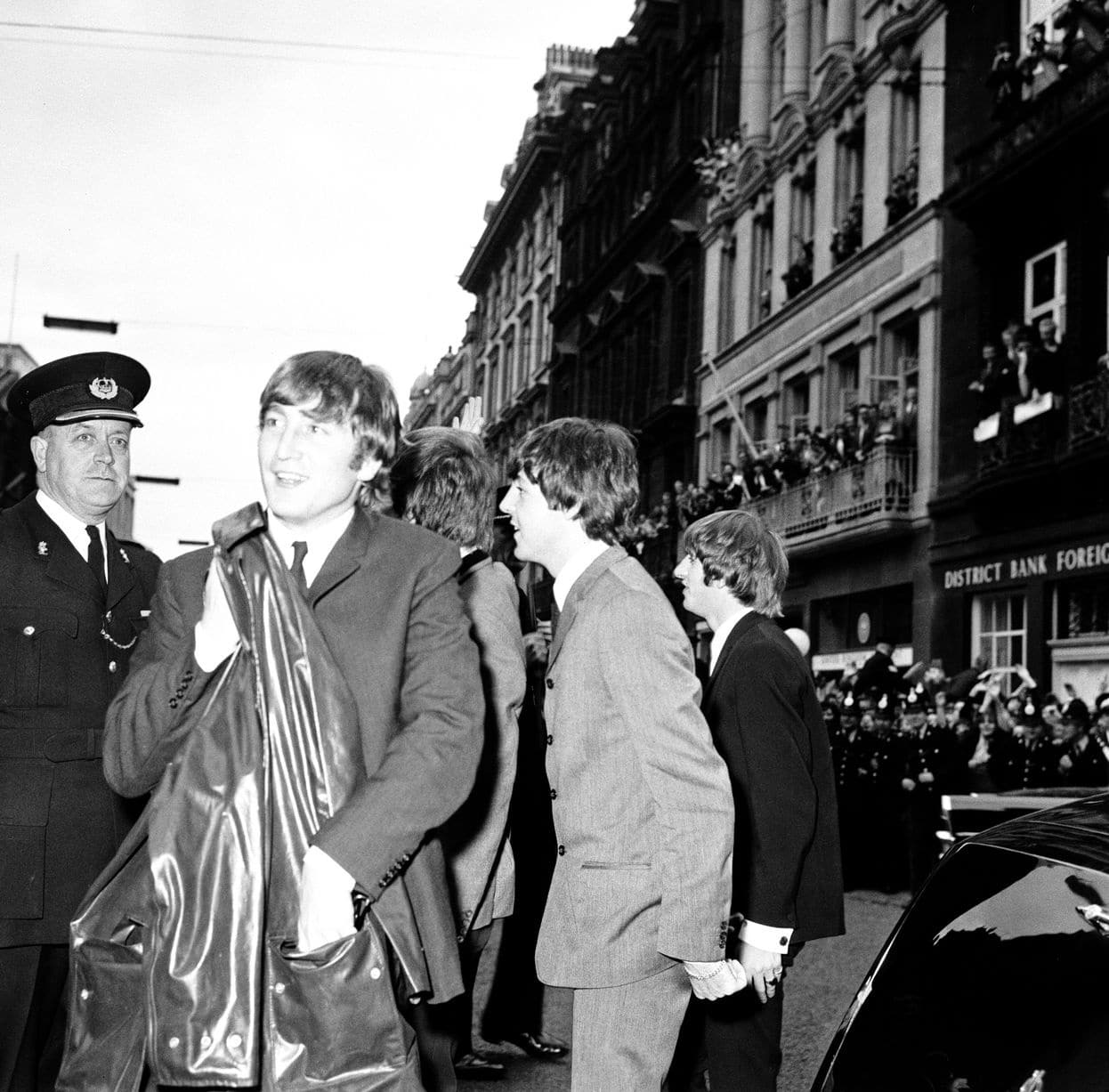 John Lennon vu escorté par la police sur une route remplie de fans à Liverpool – juillet 1964  (Image : Mirrorpix)
