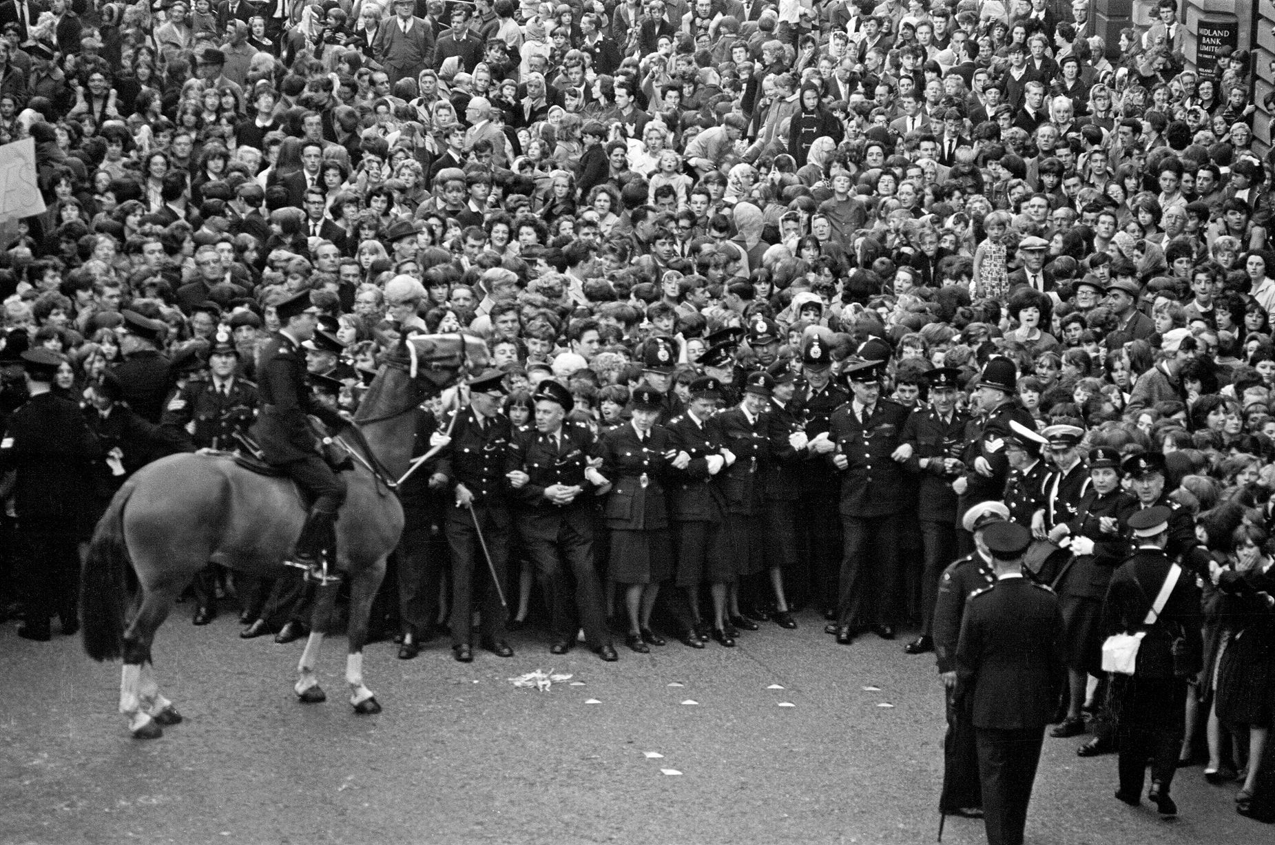 Les fans font la queue dans les rues dans l'espoir de voir les Beatles arriver pour la première à Liverpool. juillet 1964  (Image : Mirrorpix)