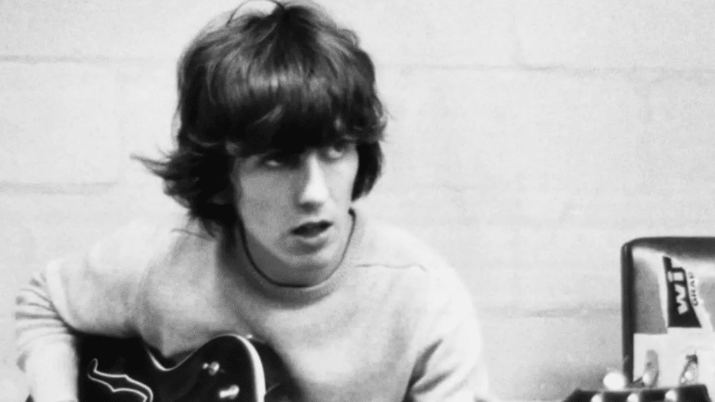 George Harrison souriant avec sa guitare