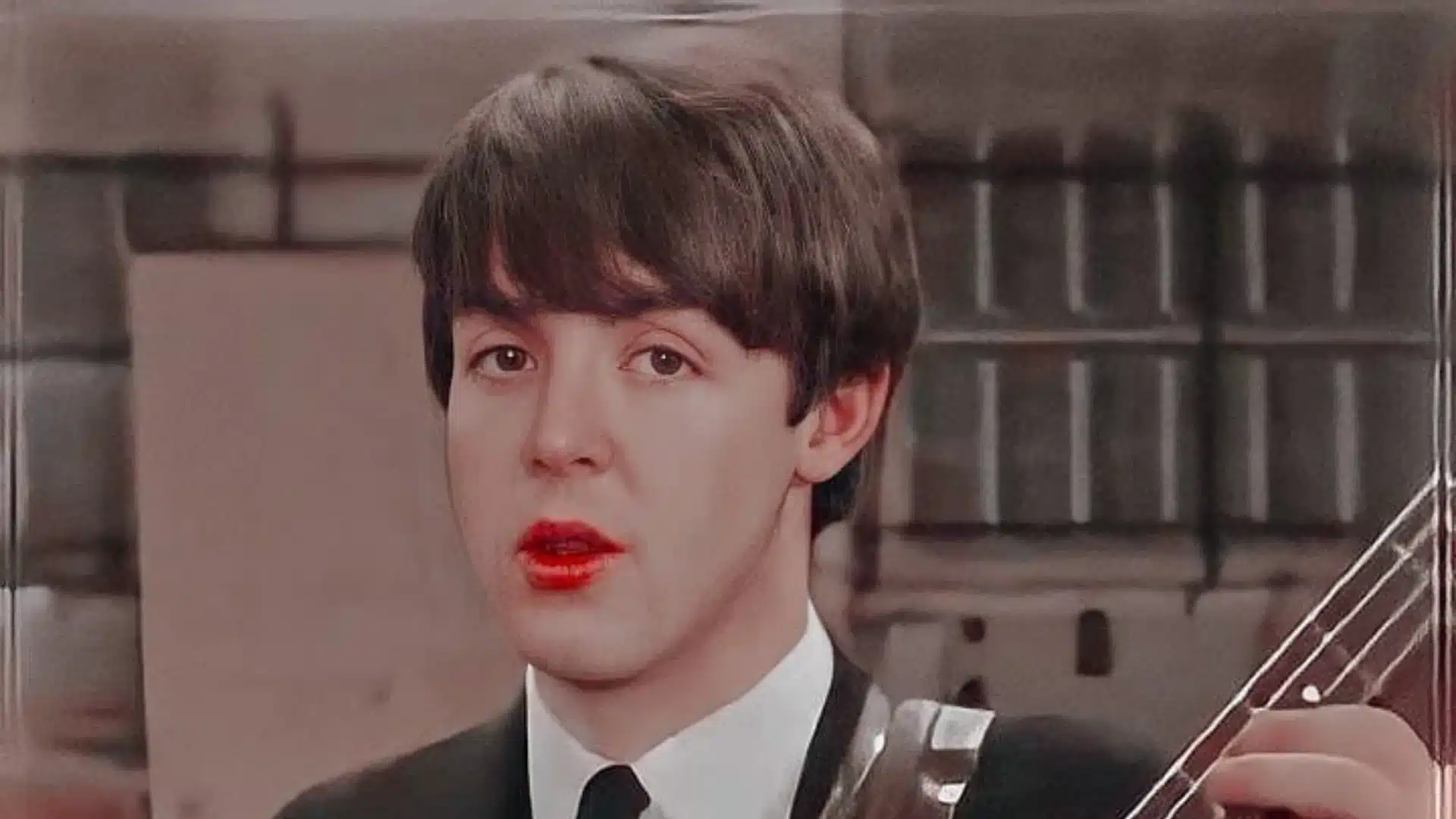 Paul McCartney jouant une guitare acoustique en studio, icône des Beatles