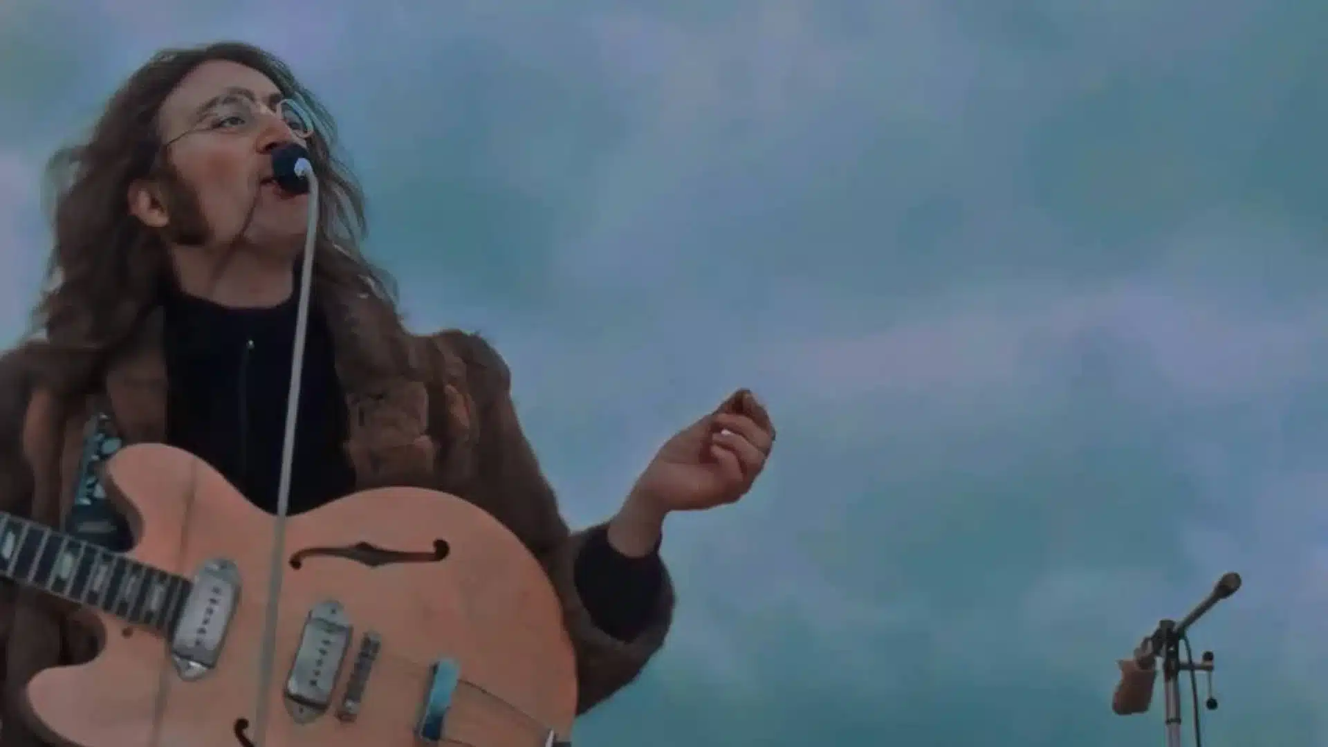 John Lennon jouant une guitare acoustique J160E, instrument de prédilection des Beatles